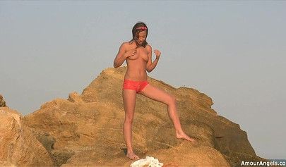 Gorgeous young nubile stripping nude and showing off her perfect body on the beach