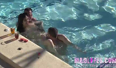 Beautiful dark-haired teen sucks two hard cocks and gets spitroasted in a pool