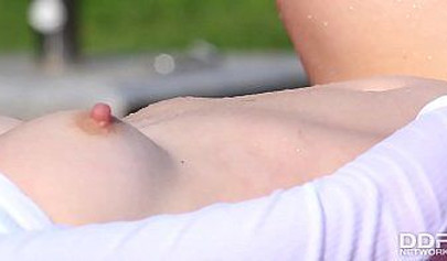 Attractive redhead teen rubs and fingers her pussy by the pool before cumming