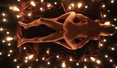 Teen couple makes love in a romantic manner surrounded by tons of nice candles