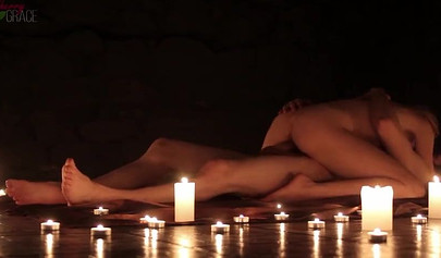 Teen couple makes love in a romantic manner surrounded by tons of nice candles
