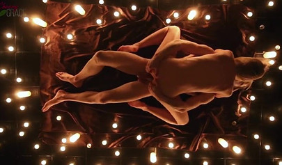 Teen couple makes love in a romantic manner surrounded by tons of nice candles