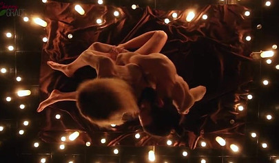 Teen couple makes love in a romantic manner surrounded by tons of nice candles