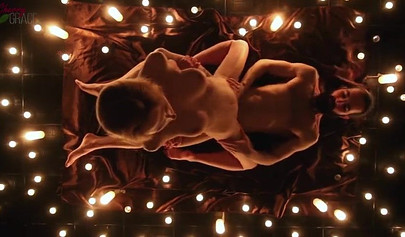 Teen couple makes love in a romantic manner surrounded by tons of nice candles