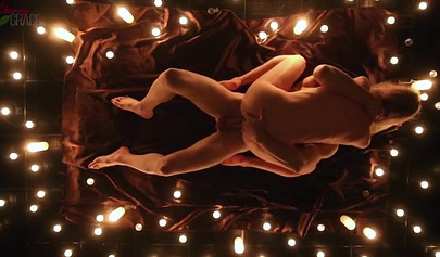 Teen couple makes love in a romantic manner surrounded by tons of nice candles