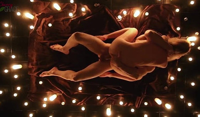 Teen couple makes love in a romantic manner surrounded by tons of nice candles