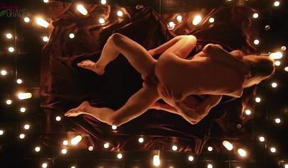 Teen couple makes love in a romantic manner surrounded by tons of nice candles