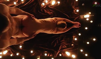 Teen couple makes love in a romantic manner surrounded by tons of nice candles