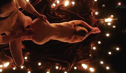 Teen couple makes love in a romantic manner surrounded by tons of nice candles