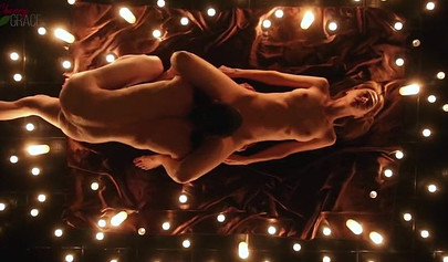 Teen couple makes love in a romantic manner surrounded by tons of nice candles