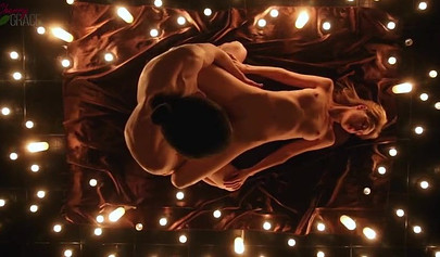 Teen couple makes love in a romantic manner surrounded by tons of nice candles