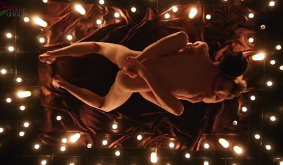 Teen couple makes love in a romantic manner surrounded by tons of nice candles