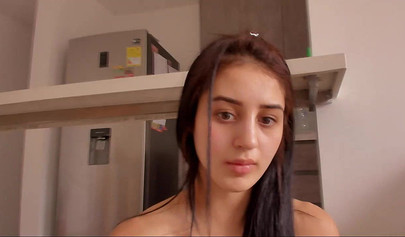 Brunette teen shows her beautiful body and smears it with lotion in the kitchen