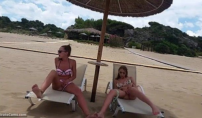 Petite blonde and brunette masturbates on the beach in the public changing room