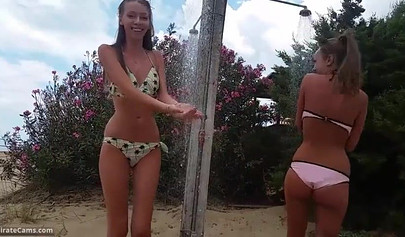 Petite blonde and brunette masturbates on the beach in the public changing room