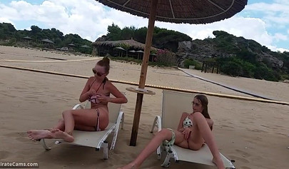 Petite blonde and brunette masturbates on the beach in the public changing room