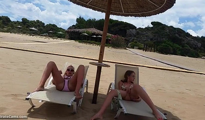 Petite blonde and brunette masturbates on the beach in the public changing room