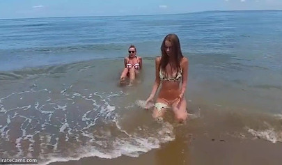 Petite blonde and brunette masturbates on the beach in the public changing room
