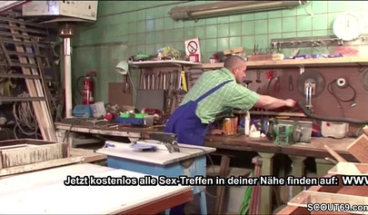 Sensual whore in fishnets fucks on a table in a workshop