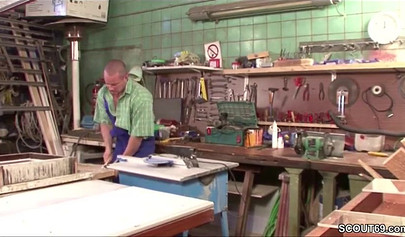 Sensual whore in fishnets fucks on a table in a workshop