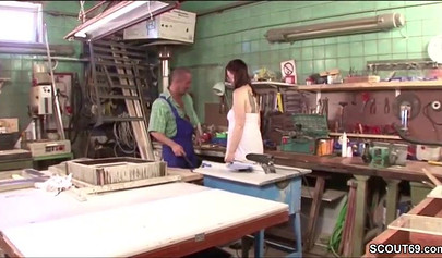 Sensual whore in fishnets fucks on a table in a workshop