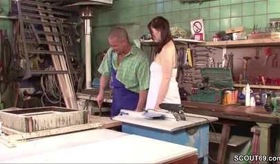 Sensual whore in fishnets fucks on a table in a workshop