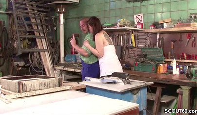 Sensual whore in fishnets fucks on a table in a workshop