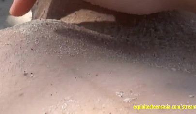 Sexy Japanese teen Arisa Mirai playing with her pussy on the sandy beach