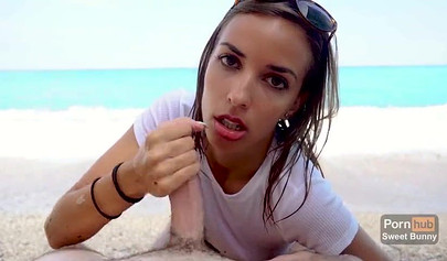 Alluring brunette with sunglasses swallows cum on the beach