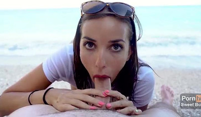 Alluring brunette with sunglasses swallows cum on the beach