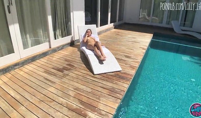 Slutty oiled brunette riding big cock in public by the pool