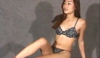 Petite Asian brunette teen fingering her pussy during photoshoot