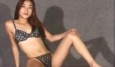 Petite Asian brunette teen fingering her pussy during photoshoot