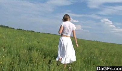 Attractive amateur teen strips in the filed and fingers her coochie