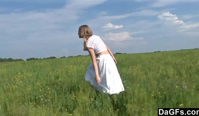 Attractive amateur teen strips in the filed and fingers her coochie