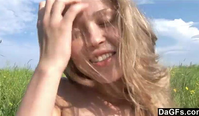 Attractive amateur teen strips in the filed and fingers her coochie