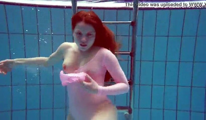 Redhead teen strips naked at the pool and shows her innocent body