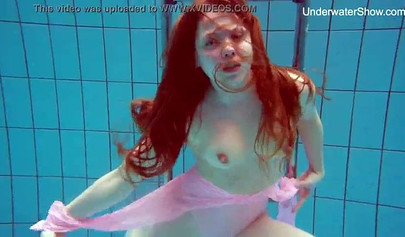 Redhead teen strips naked at the pool and shows her innocent body