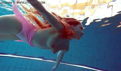 Redhead teen strips naked at the pool and shows her innocent body