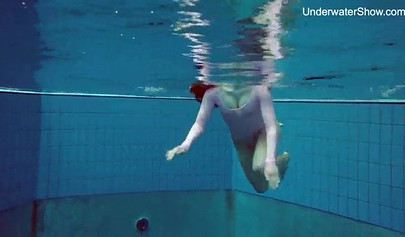 Redhead teen strips naked at the pool and shows her innocent body