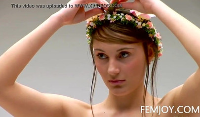 Sensational teen with big tits posing nude with a flowers crown on her head