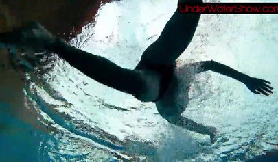 Gorgeous teen strips naked while swimming in the pool