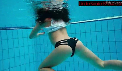 Gorgeous teen strips naked while swimming in the pool