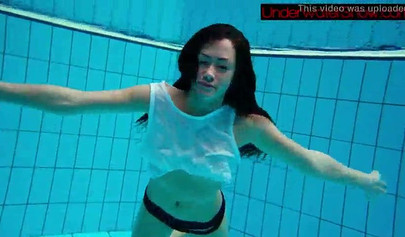 Gorgeous teen strips naked while swimming in the pool