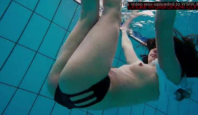 Gorgeous teen strips naked while swimming in the pool