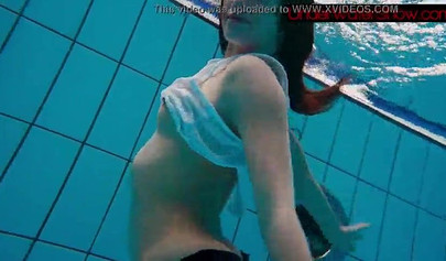 Gorgeous teen strips naked while swimming in the pool