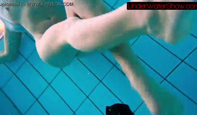 Gorgeous teen strips naked while swimming in the pool