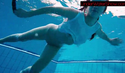 Gorgeous teen strips naked while swimming in the pool