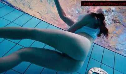 Gorgeous teen strips naked while swimming in the pool