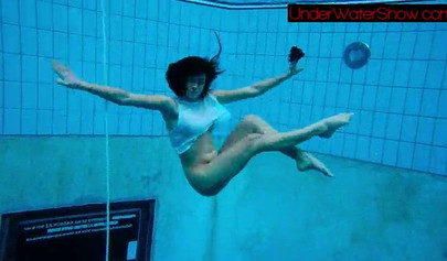 Gorgeous teen strips naked while swimming in the pool